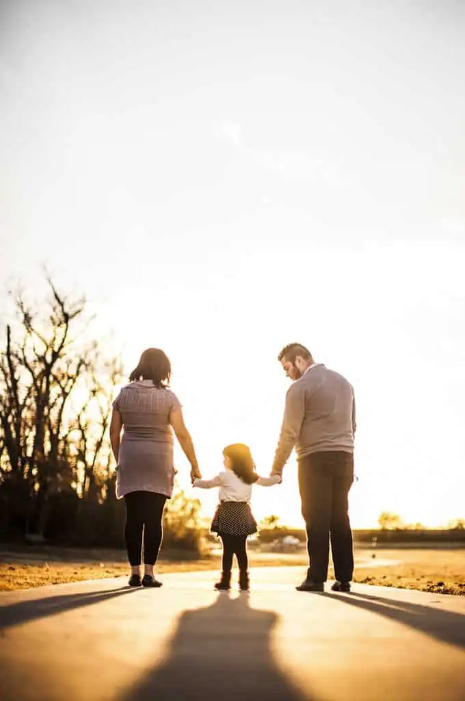 Photo of Family Standing Outdoors During Golden Hour